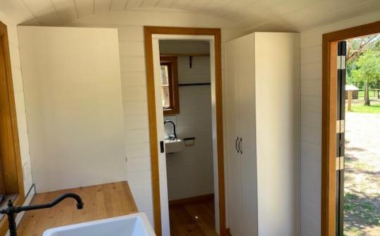 View inside a tiny house at Eldorado featuring the kitchen sink and a corridor leading to a bathroom