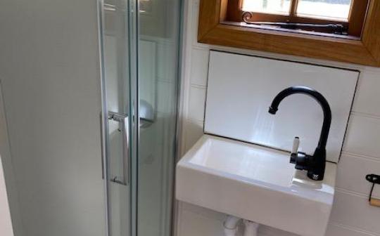 Modern tiny house bathroom with a sleek glass shower and a stylish sink